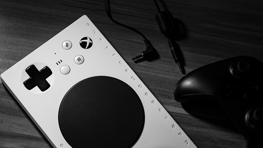 A close-up of the Xbox Adaptive Controller with 2 mono audio cables and an Xbox controller